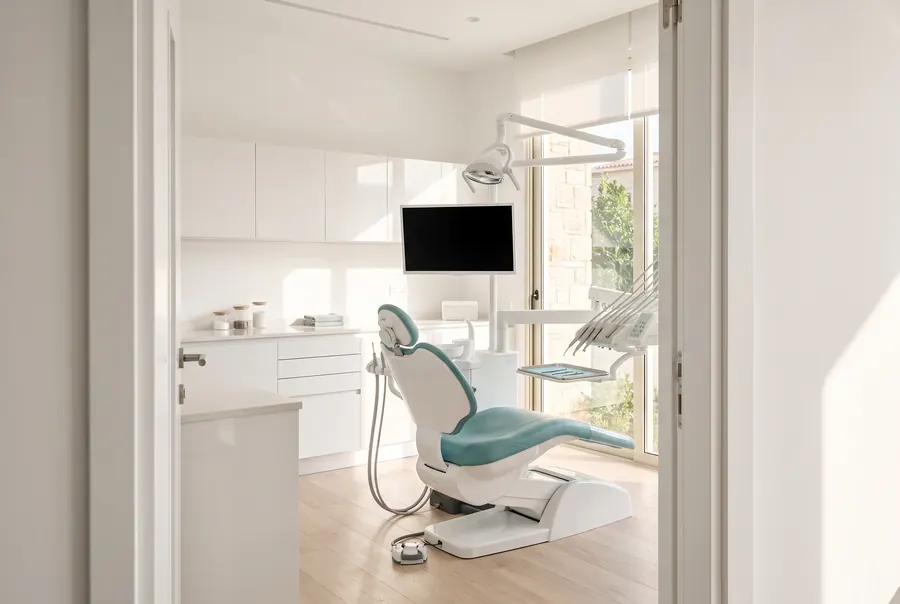 Treatment room with a dental chair, operating light and instrument tray